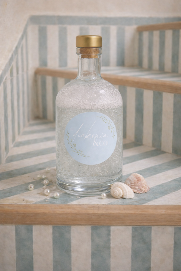 Bubble bath soap bottle with a gold cap on a striped surface