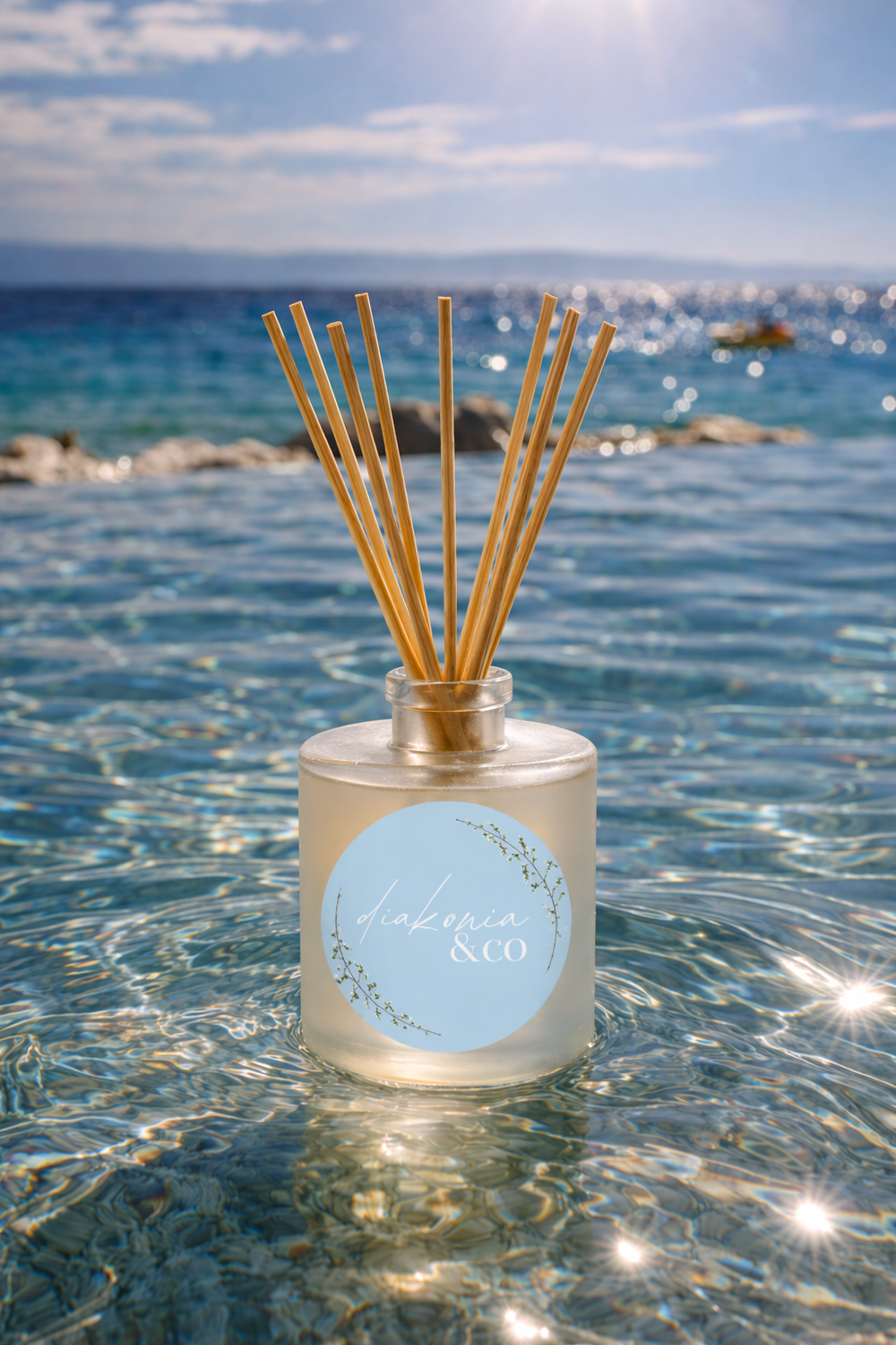 Reed diffuser with a label in clear water with a blue sky background