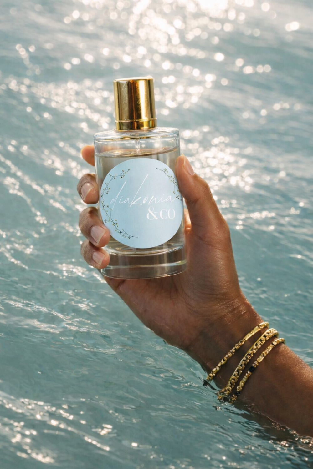 Hand holding a perfume bottle with a scenic background