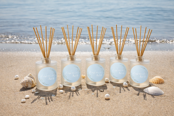 5 reed diffusers on a beach