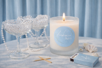 Candle with a blue label on a table with decorative items